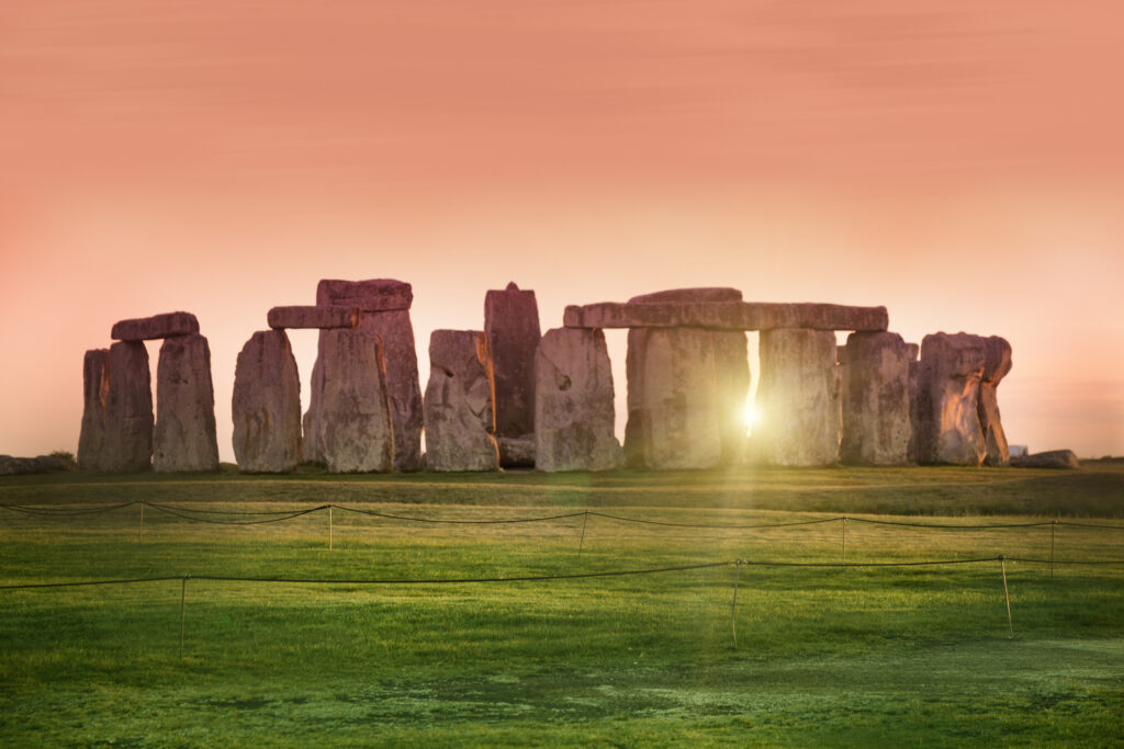The sun's rays reflect through the megaliths of Stonehenge, inviting spiritual reflection at the  Solstice.