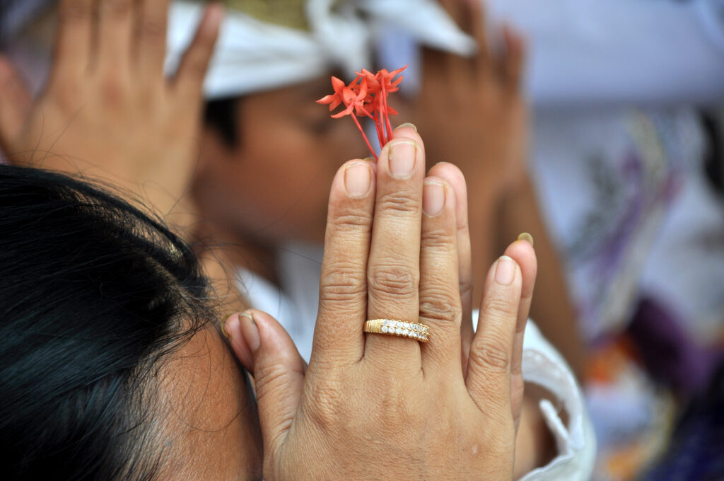 Sacred offering in Bali, clasping flowers in Hindu prayer